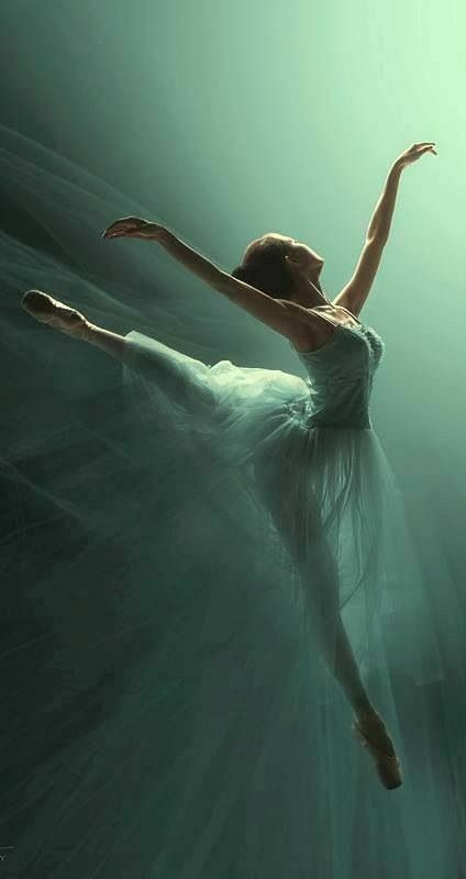 a ballerina is floating in the water with her arms outstretched and legs spread out