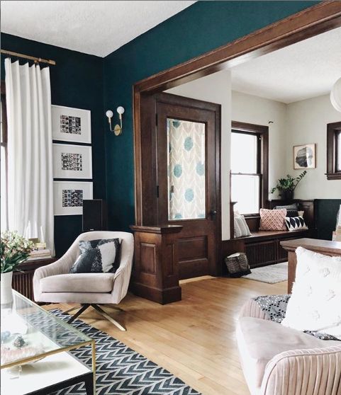 a living room with blue walls and white furniture in the center, along with wood flooring