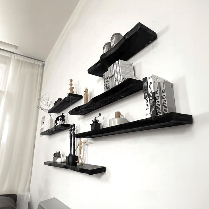 three black shelves on the wall with books