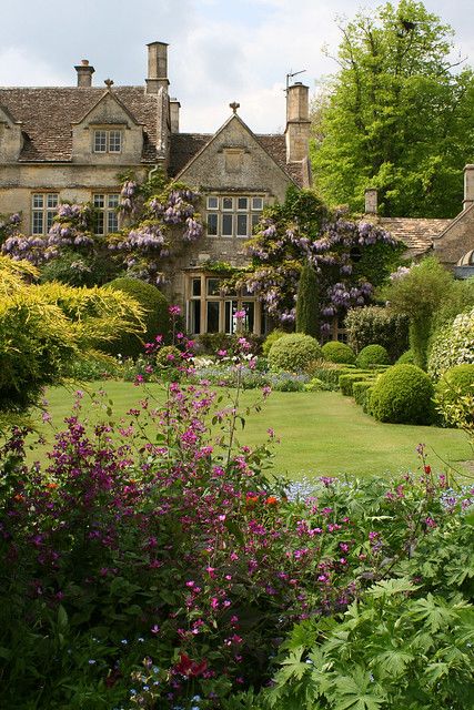 an image of a house in the middle of some bushes and flowers, with text overlay that reads pin it