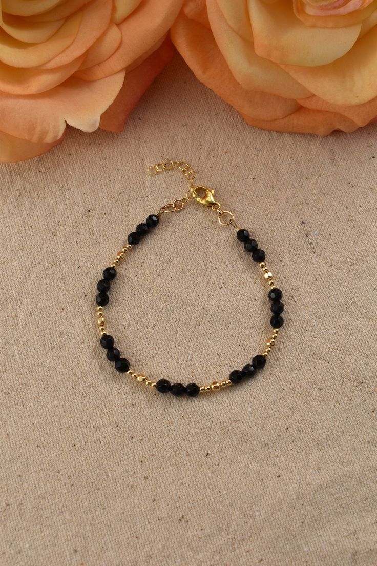 Black Onyx Bead Bracelet, 14Kt Gold Filled - Gemstone Jewelry Gifts for Women Adjustable 7 inches - 8 inches Black and gold create a perfectly elegant combination. This bracelet is easy to match with any outfit, adding an effortless elegance. You will love the bright sparkle of the gold beads, and the flashes from the dark surfaces of the faceted Onyx beads.  What is Gold Filled? Gold filled jewelry has a layer of solid gold that is 100 times thicker than that of gold plated jewelry. It is hypoallergenic, resistant to tarnish, and will not chip or fade over time. Gold filled has an appearance nearly identical to solid gold, but with a more affordable price. It is highly durable and with proper care will last a lifetime. Browse my shop: ALLDANAE.etsy.com Gold Crystal Bracelet With Round Beads And Beaded Chain, Gold Crystal Bracelet With Beaded Chain, Dainty Beaded Gold Bracelet, Adjustable 14k Gold-filled Bracelets With Faceted Beads, Gold Beaded Bracelets With Onyx Gemstones, Gold Onyx Beaded Bracelets With Gemstones, Dainty Black Beaded Bracelets For Gift, Dainty Adjustable Black Beaded Jewelry, Hand-strung Onyx Jewelry In Gold