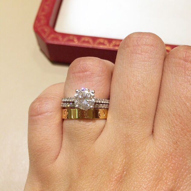 a woman's hand holding a ring with a diamond on it