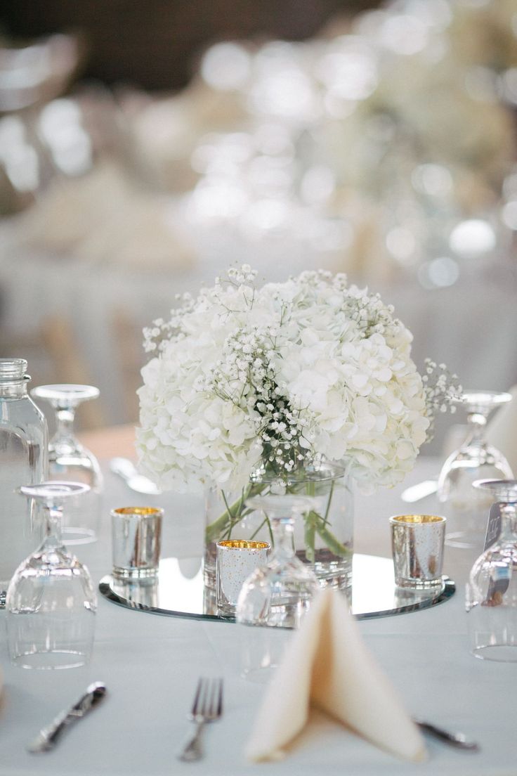 the centerpieces are arranged in glass vases with baby's breath flowers