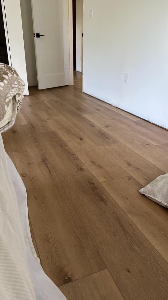 an empty room with hard wood floors and white walls