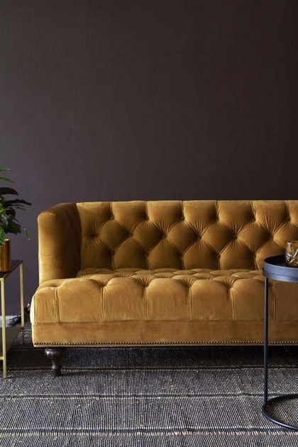 a living room with a couch, table and potted plant