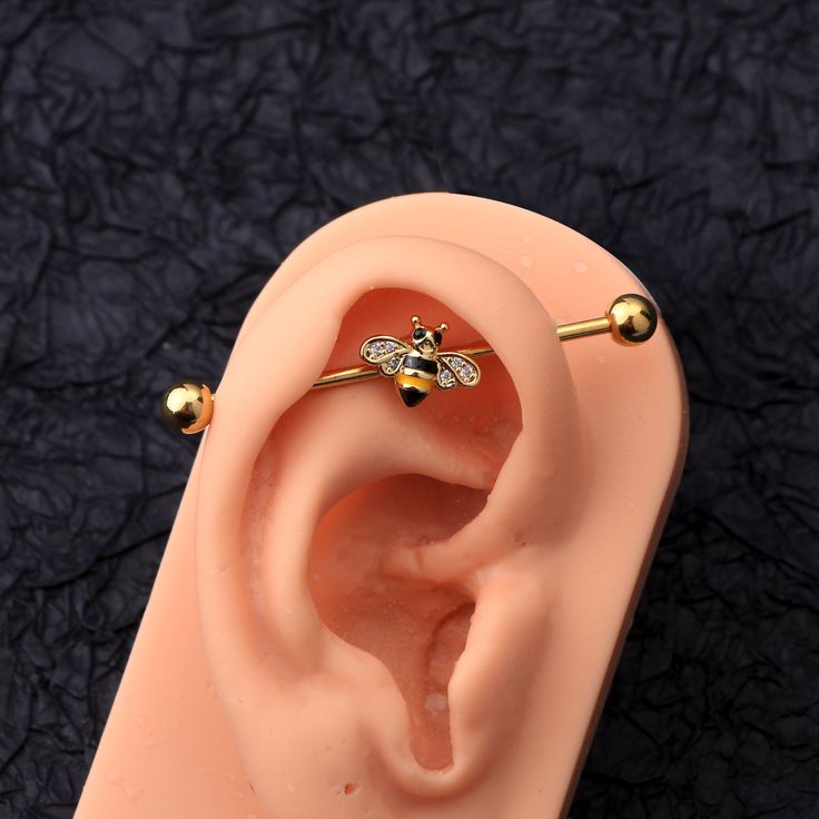 The honeybee industrial barbell adds an extra layer of cuteness to your industrial piercing. Material: The bar is made of 316L stainless steel, plated with 18k gold, which can be used for a long time. Fine Craftsmanship: High polished smooth surface, comfortable to wear without sharp edges, and no irritation to your skin. Size: Bar Thickness: 14 Gauge=1.6mm Bar Length: 38mm Ball Diameter: 5mm We strive to bring you the best quality body jewelry for the best prices, along with many new captivatin Minimalist Industrial Piercing, Industrial Bar Jewelry, Bar Peircings Cute, Industrial Piercing Jewelry Gold, Pretty Industrial Piercing, Indistruel Piercing, Industrial Piercing Earrings, Industrial Pericing, Ear Piercings Bar