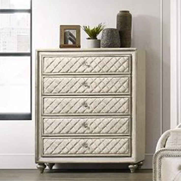 a white dresser sitting next to a window