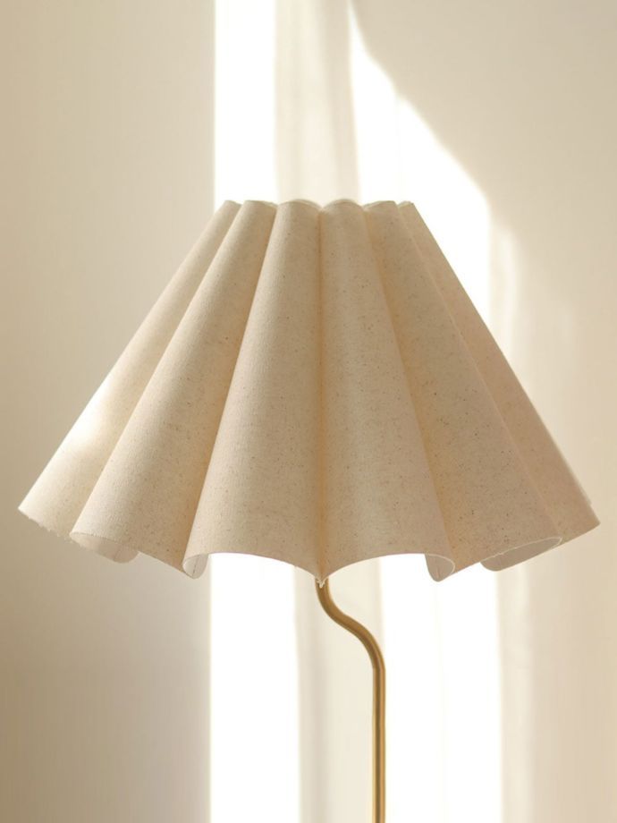 a lamp that is sitting on top of a table in front of a white wall