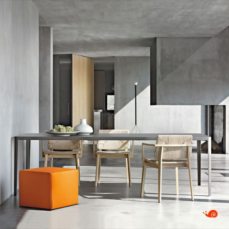 a table and chairs in a room with concrete walls