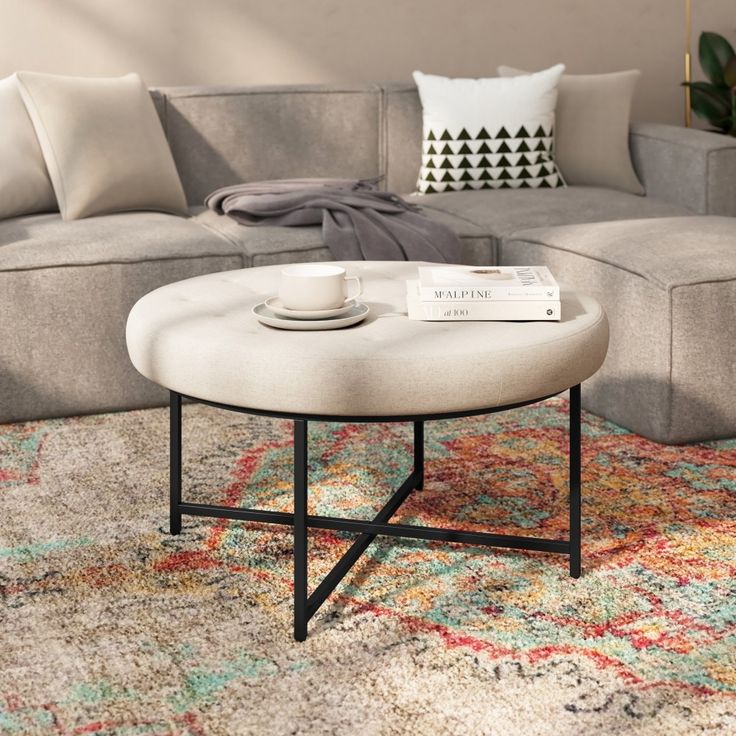 a living room with a couch, coffee table and rug on the floor in front of it