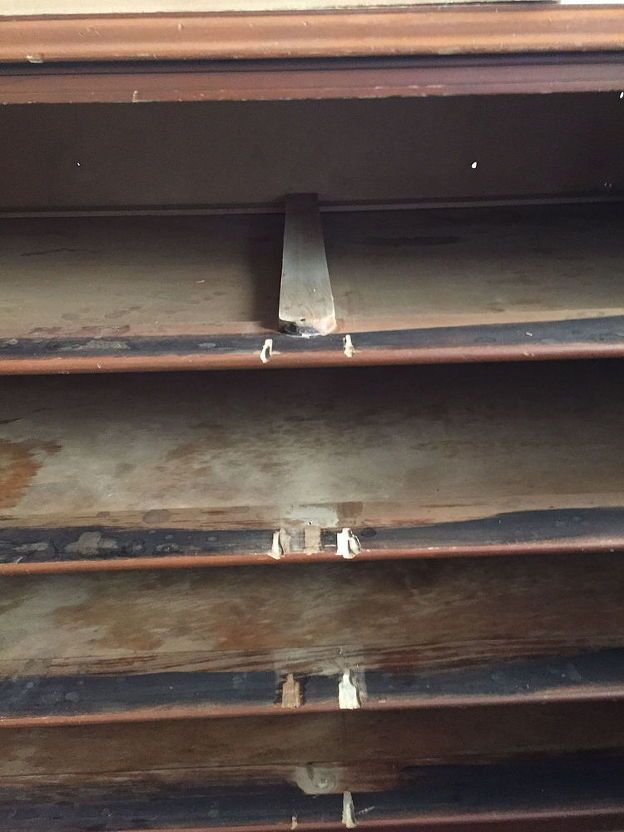 an old metal shelf with some rust on the top and bottom shelves in front of it