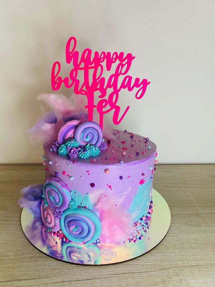 a birthday cake decorated with purple and blue icing