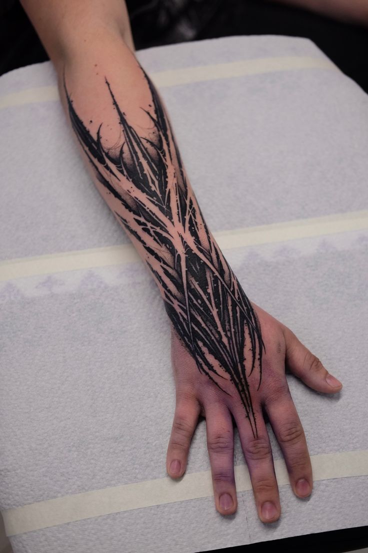 a person's hand with a tattoo on it, resting on a pillow in front of their arm