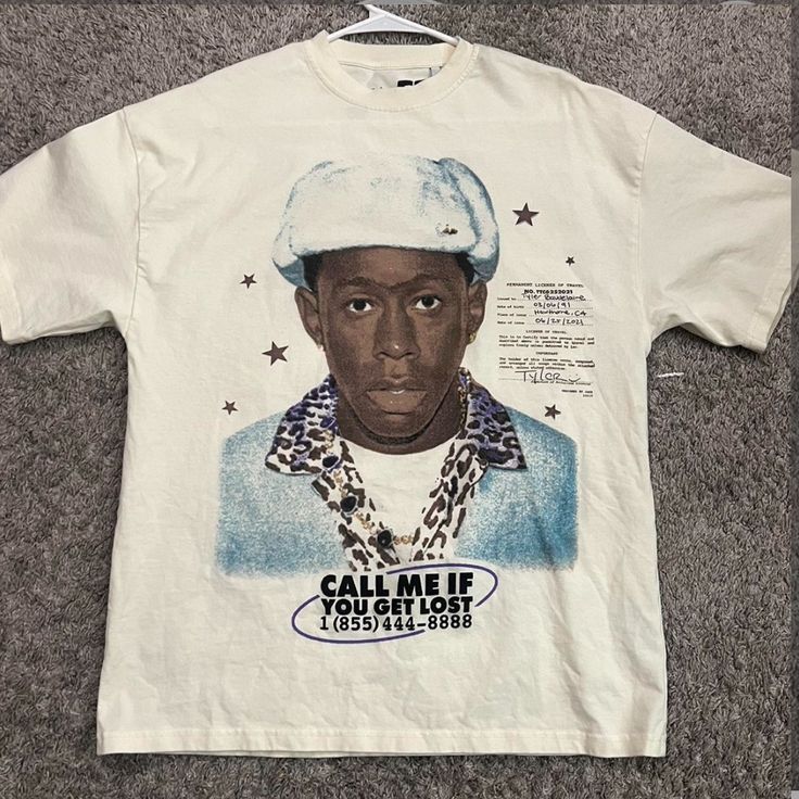 a white t - shirt with an image of a man wearing a hat on it