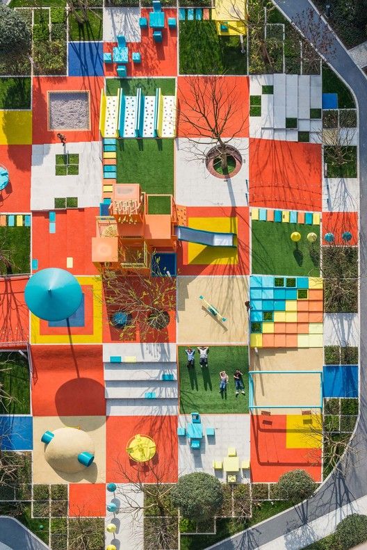 an aerial view of a park with colorful benches and tables