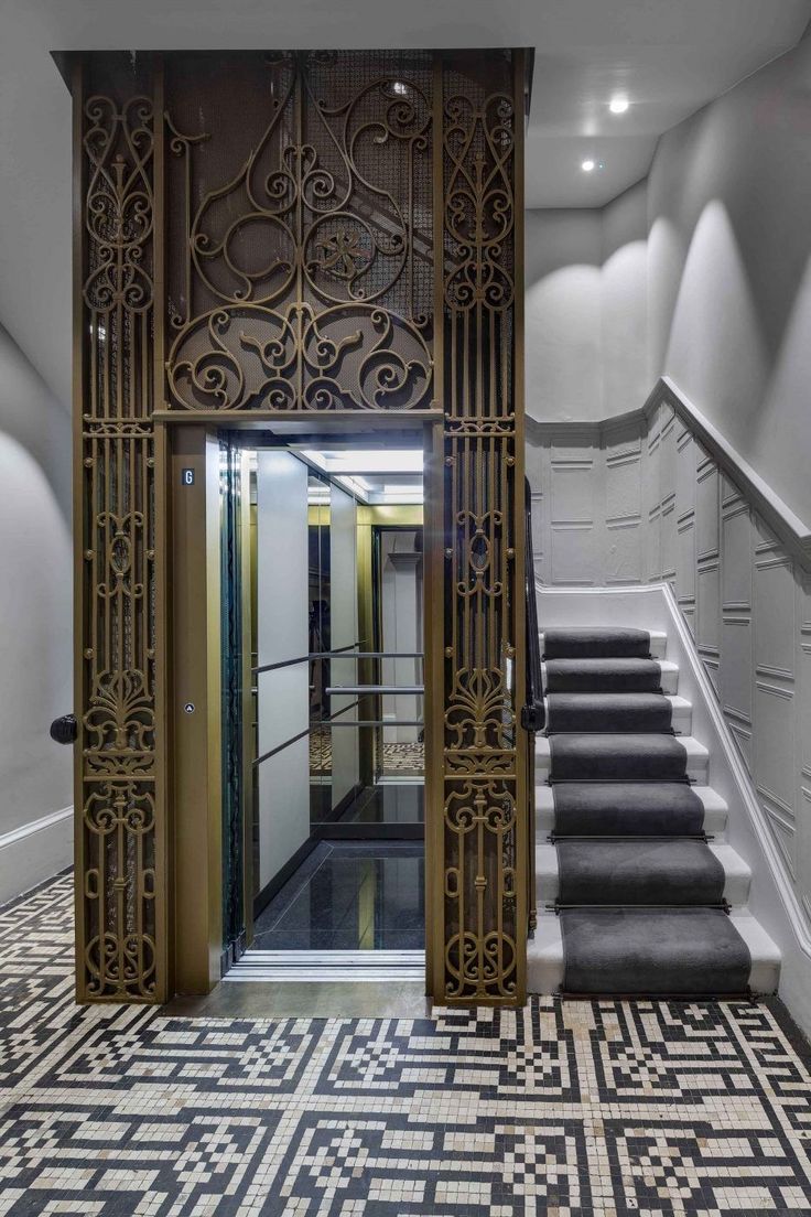 the entrance to an office building with black and white tile flooring, stairs and walls