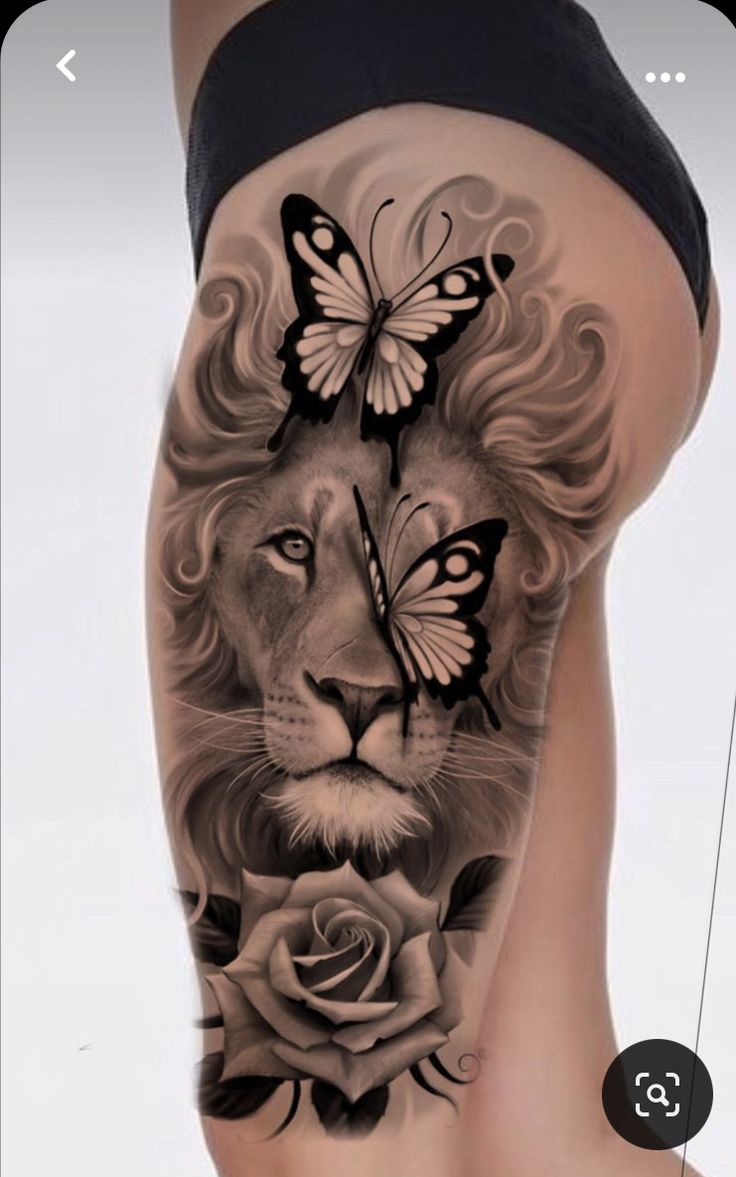 a woman's thigh with a lion and butterfly tattoo on it