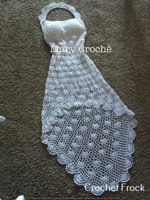 a white crocheted dress on the ground