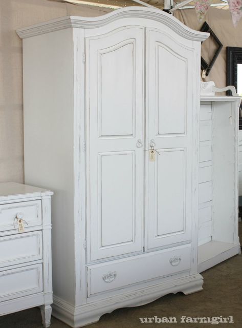 a white armoire and dresser in a room