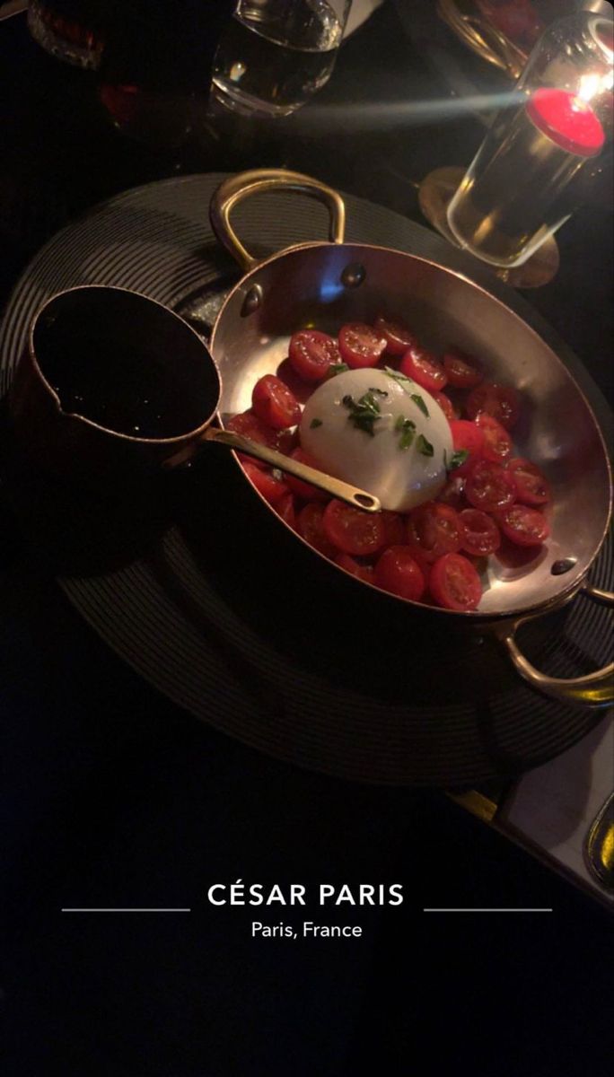 a pan filled with food sitting on top of a table next to glasses and utensils