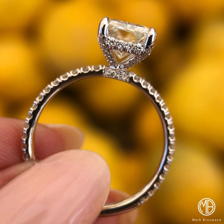 a close up of a person holding a diamond ring