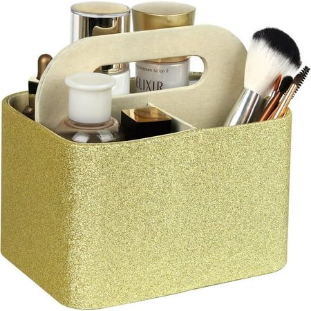 a gold caddy with makeup brushes and other items in it