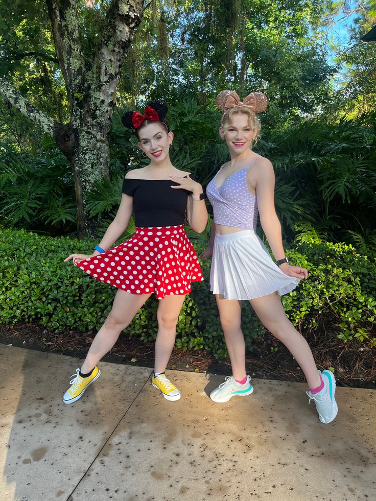 two young women dressed in minnie mouse costumes posing for the camera with their arms around each other