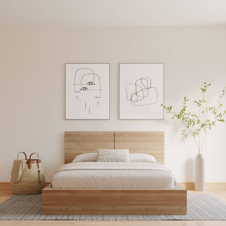 a bedroom with two paintings on the wall and a bed in the foreground,