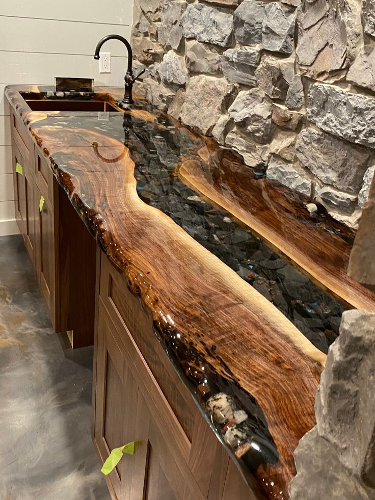 a kitchen counter top made out of wood and stone with water running down the side