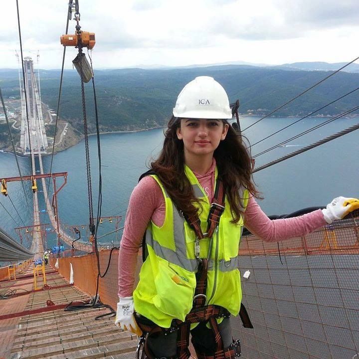 a woman in safety gear standing on top of a building