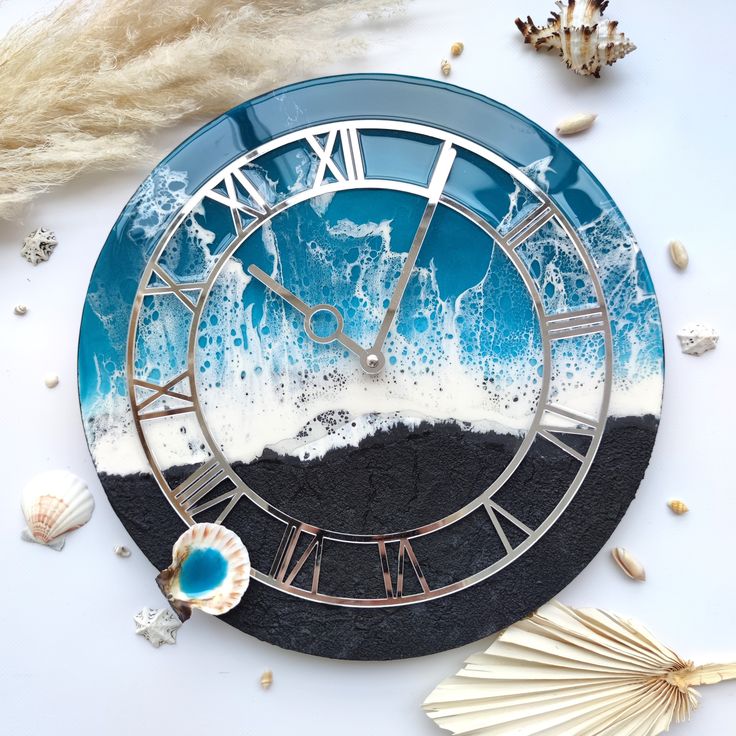 a blue and white clock sitting on top of a table next to seashells