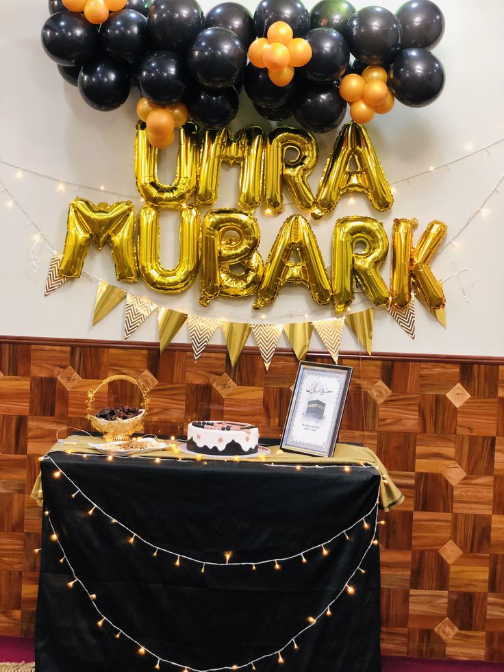 a black table topped with balloons next to a sign that says ultra mubark