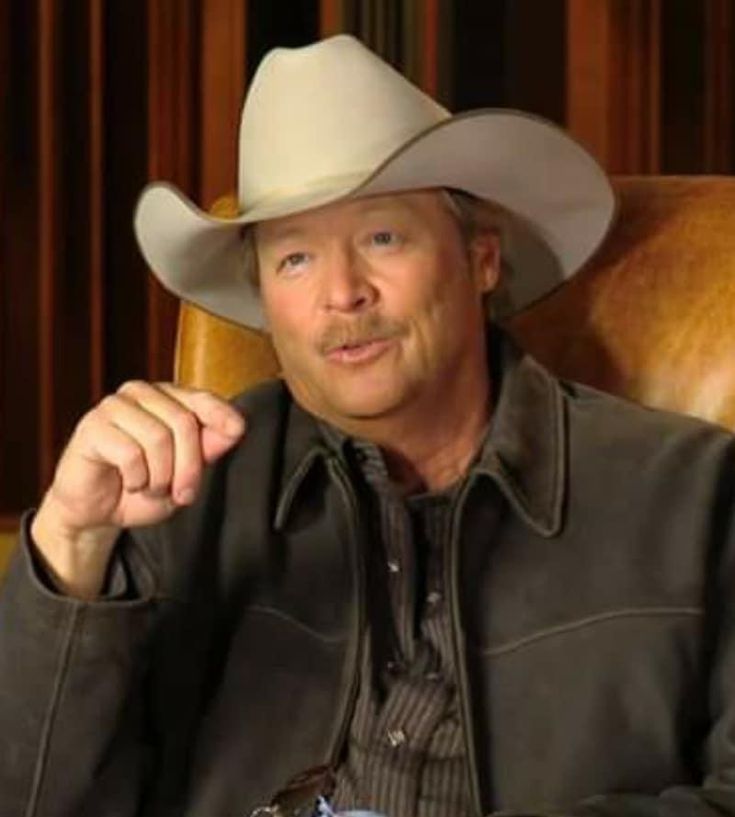 a man sitting in a chair wearing a cowboy hat