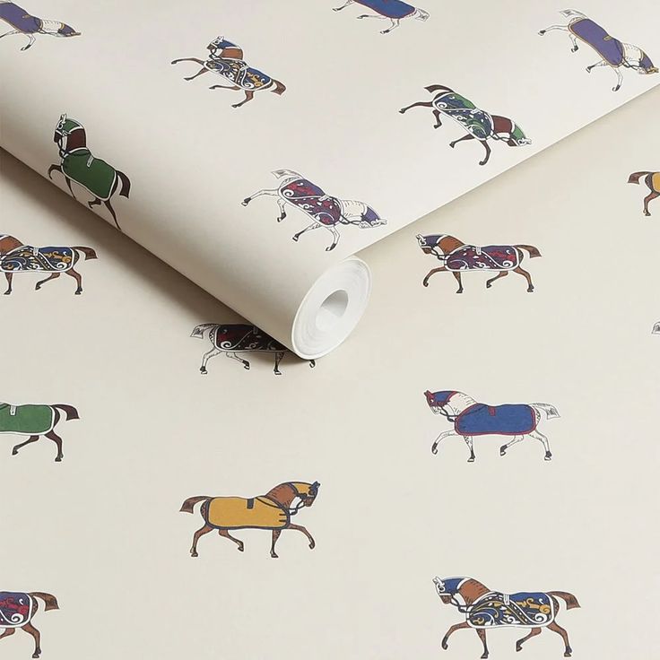 a white wallpaper with horses and jockeys on it's back ground, next to a roll of tape