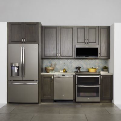 a modern kitchen with stainless steel appliances and wood cabinetry, including an oven, microwave, dishwasher, and refrigerator