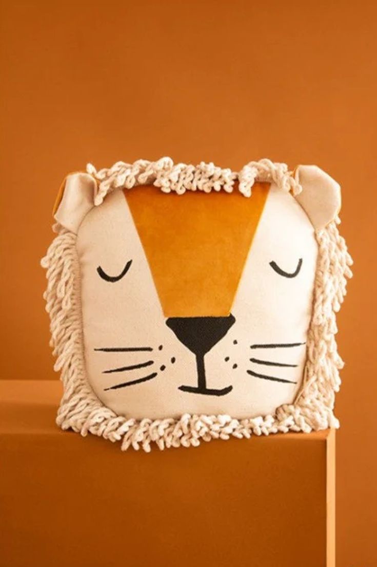 a pillow with a tiger face on top of it and fringes around the edges