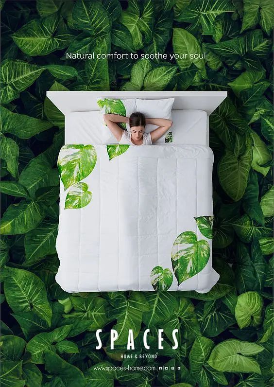 a woman laying on top of a bed covered in green leaves