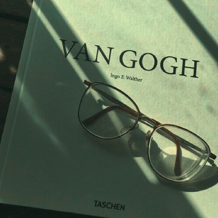 a pair of glasses sitting on top of an open copy of the book van goghn