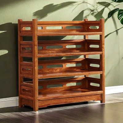 a wooden shelf sitting on top of a hard wood floor next to a green wall