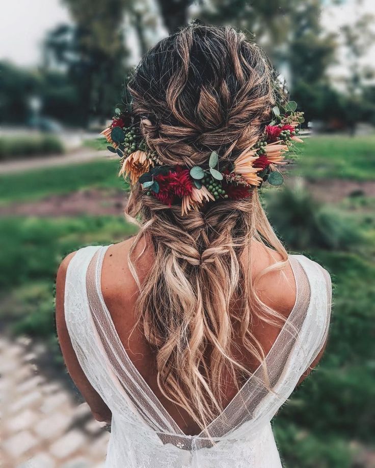 a woman with long hair and flowers in her hair is looking down at the ground