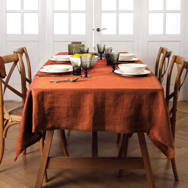 the table is set with plates and silverware on it, along with other place settings