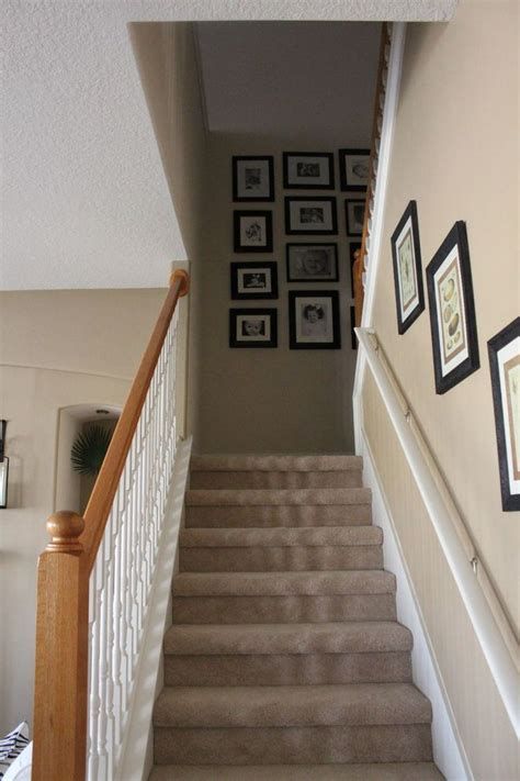 a staircase with pictures on the wall and carpeted stairs leading up to it's second floor