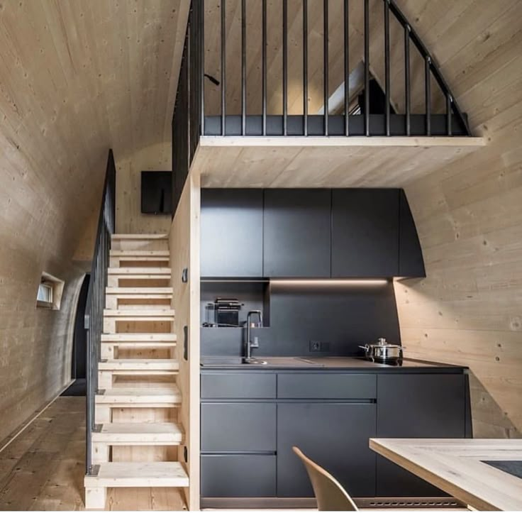 the stairs lead up to the kitchen and dining area in this modern cabin style home