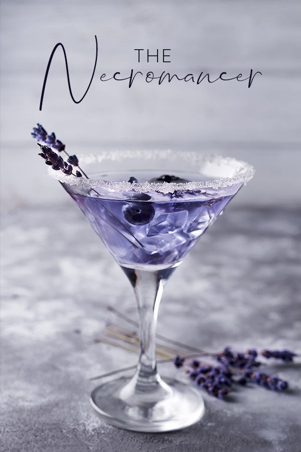 a martini glass filled with blueberries and lavender