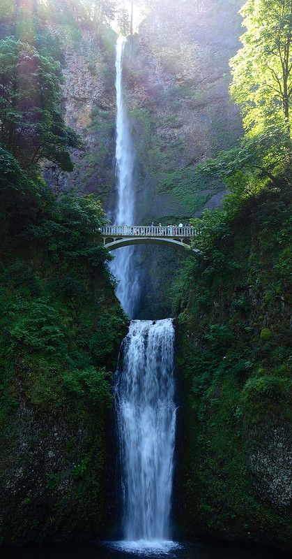 a large waterfall with a bridge over it