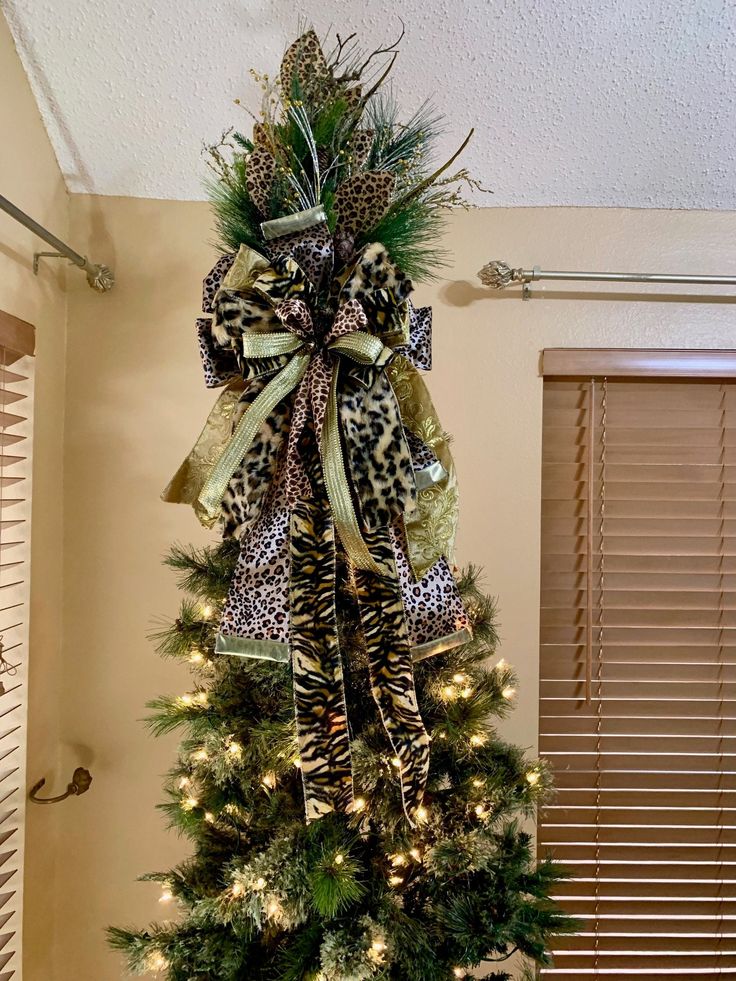 a christmas tree decorated with leopard print ribbon and lights