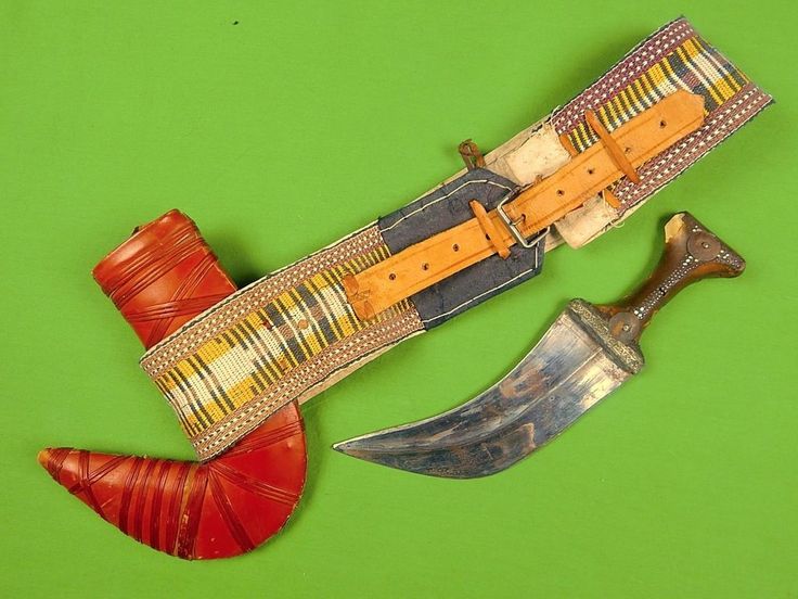 two different types of knifes on a green surface with red and yellow accessories around them