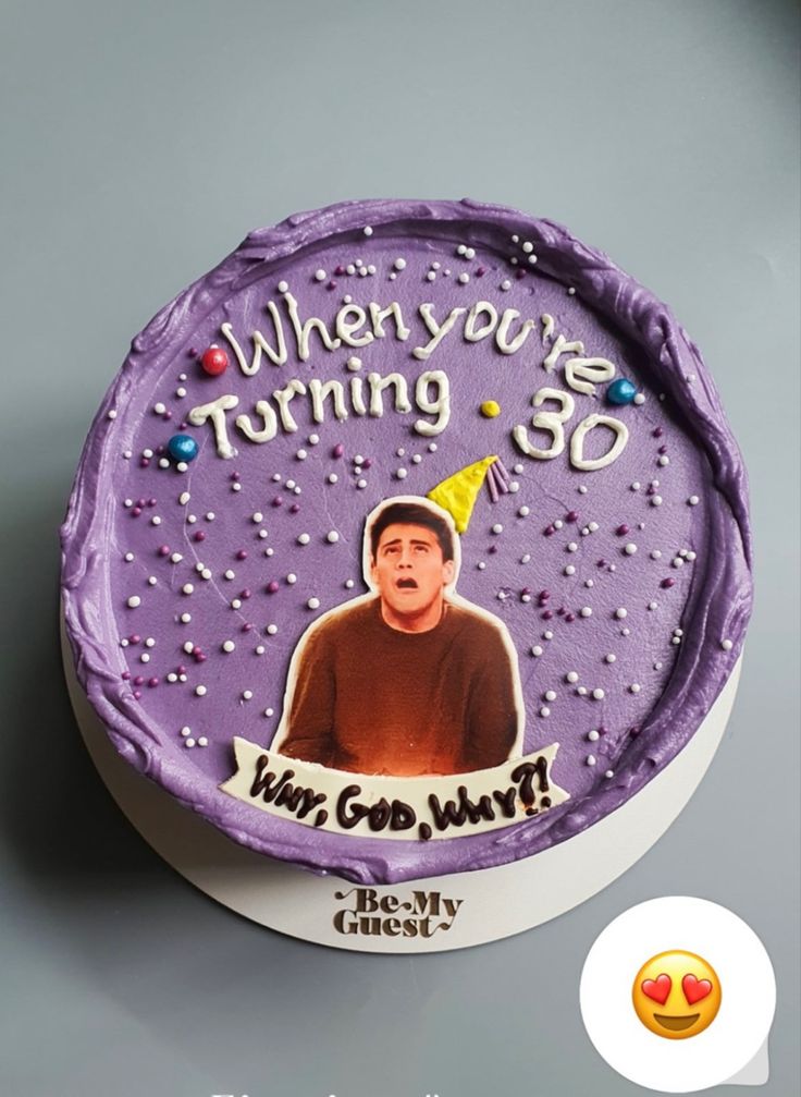 a birthday cake with the image of a man wearing a party hat on it's side