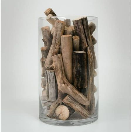 a glass vase filled with driftwood and rocks