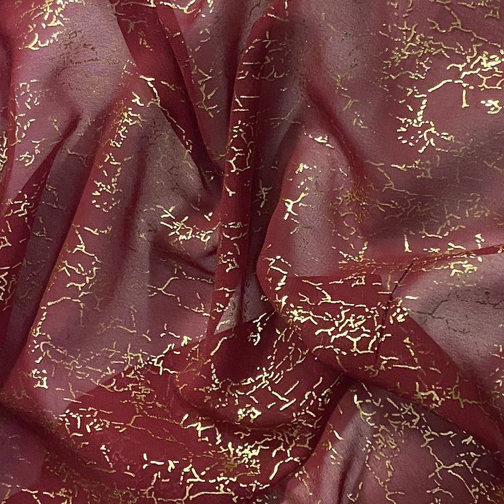 a red and gold fabric with metallic foil on it